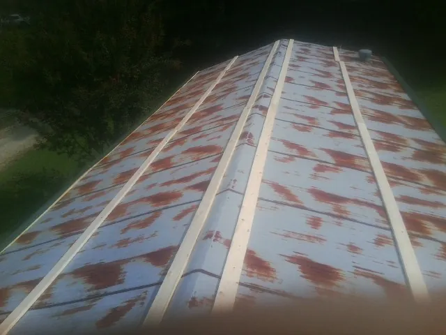 Rusted metal roof panels with new wood purlins before replacement — Storm Damage Roof Repair in Boothville by Roofing Brothers