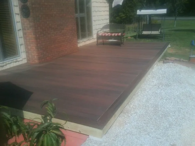 Freshly stained wood deck built against a brick home in Boothville