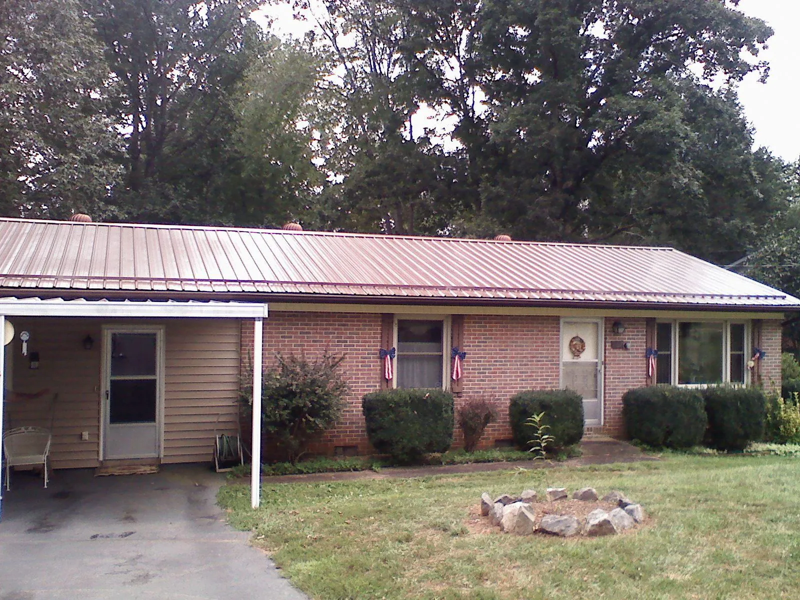 Bronze metal roof and carport on a brick ranch home — Roof Repair work by our crew in Boothville
