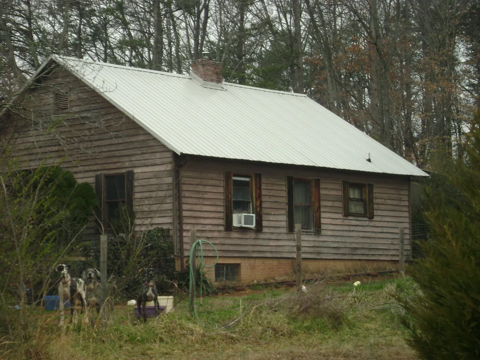 White metal roof on an old wood sided farmhouse, from a Metal Roof Installation job in Boothville